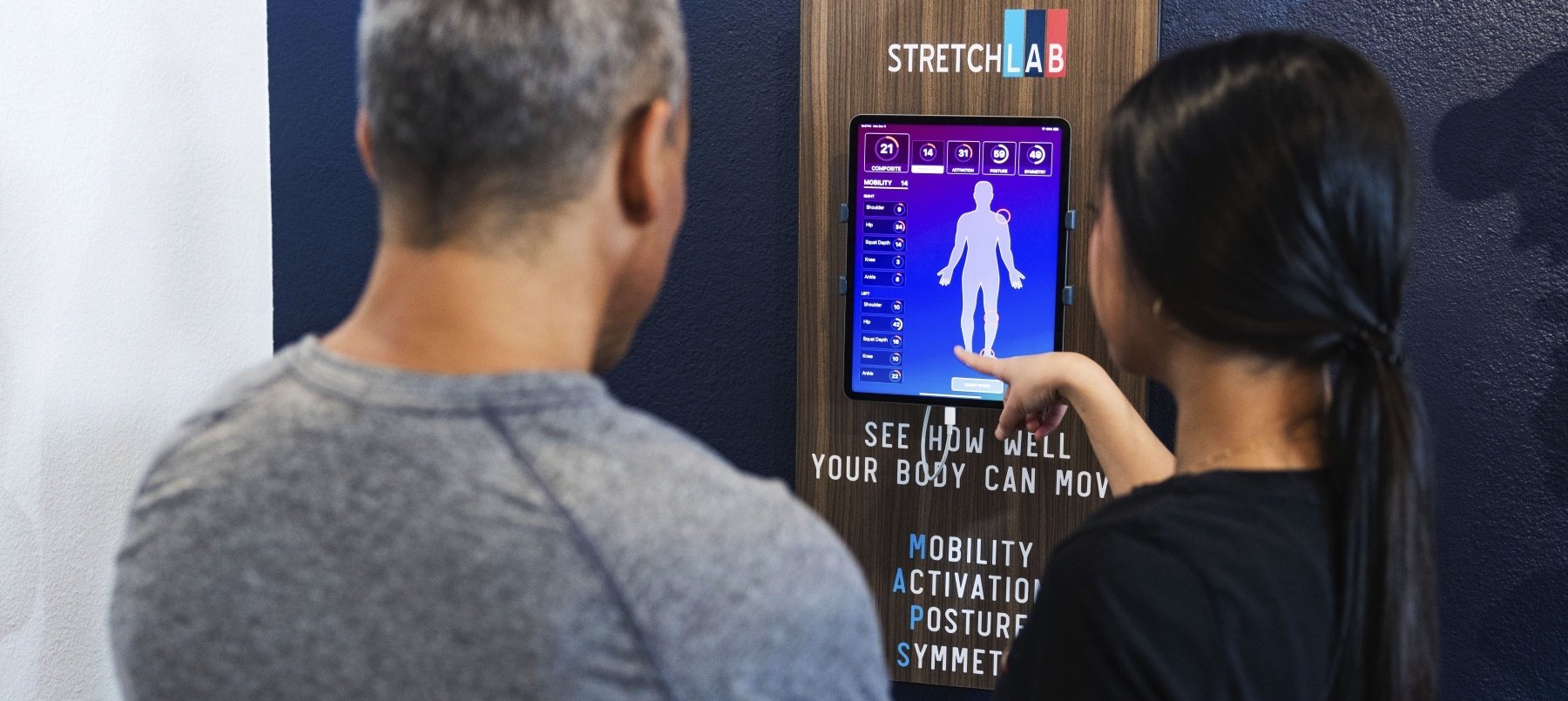 Flexologist guiding StretchLab attendee through the MAPS body assessment program